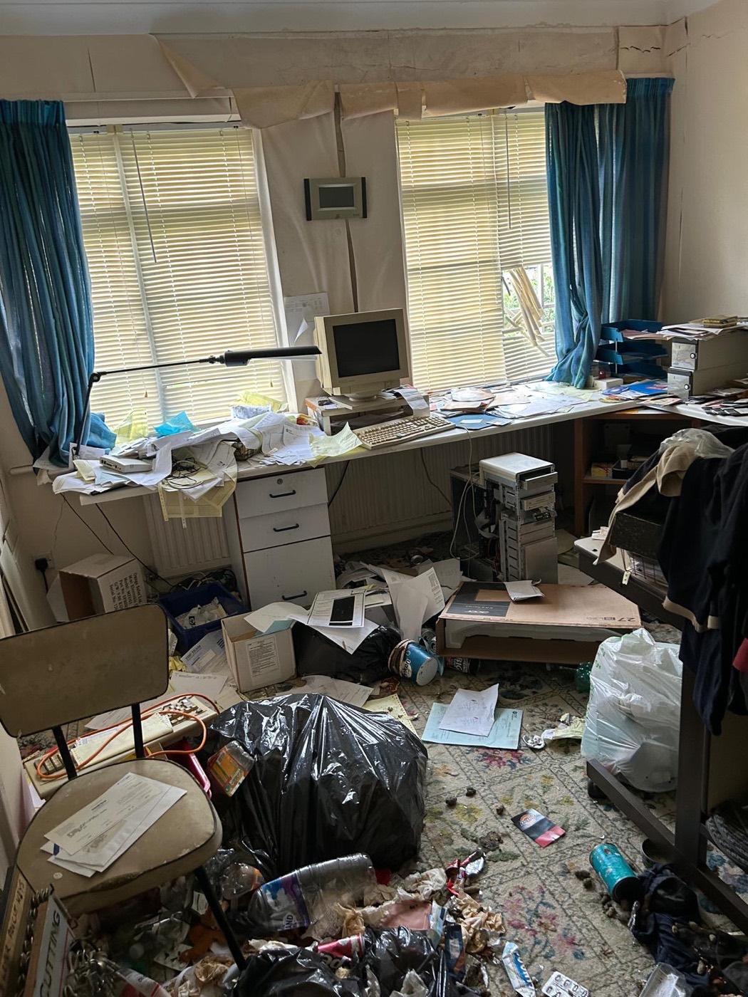 The same study as we found it, floor covered with papers, bags and boxes